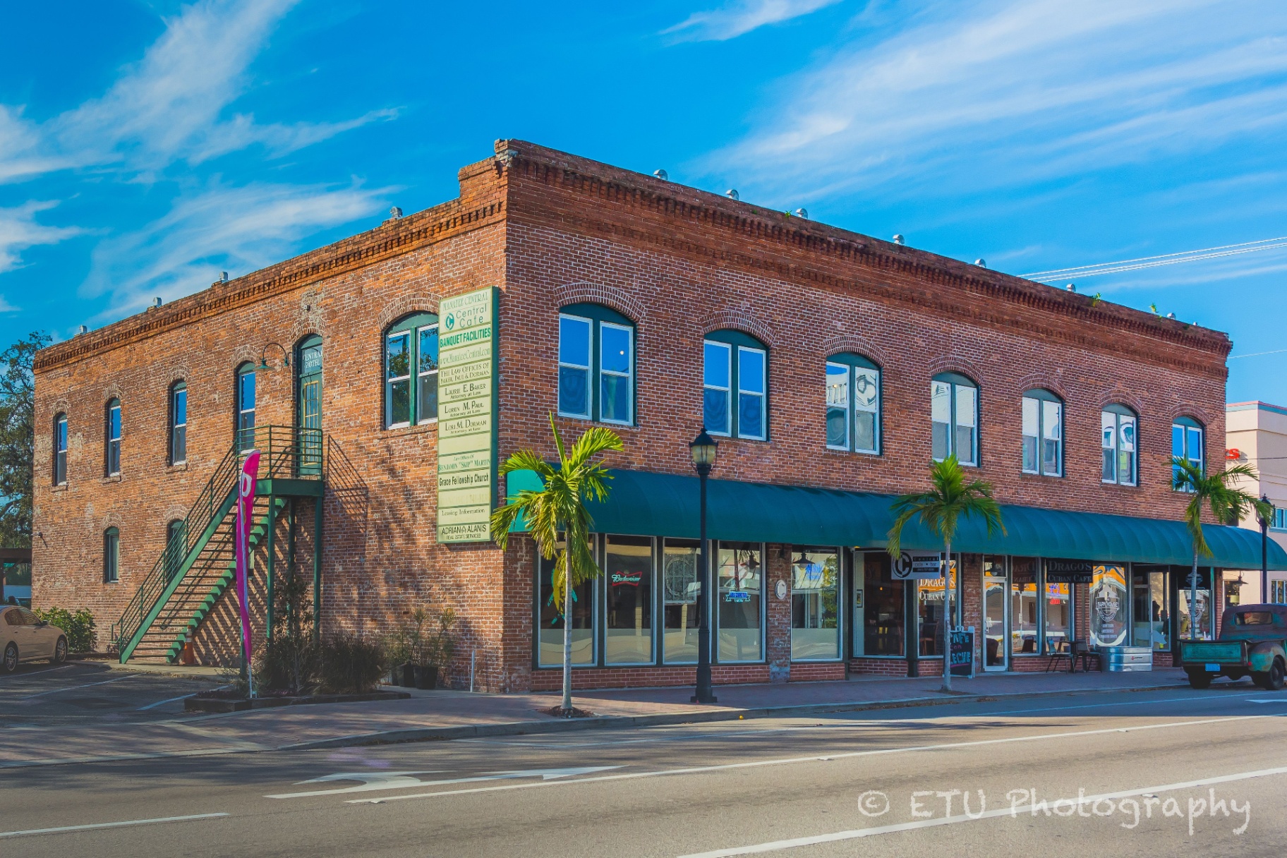 Historic brick building exterior with palm trees