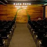 Event seating with wood backdrop and hanging lights