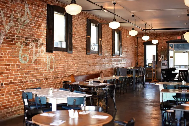 Urban loft interior with exposed brick walls, hanging lights, and tables